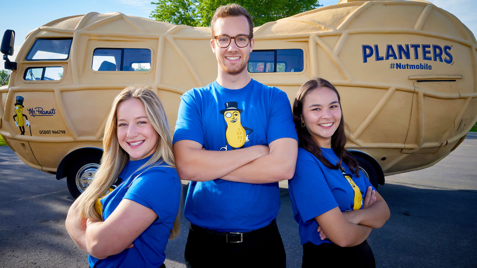 Alexa, Kevin, and Grace standing in front of the Nutmobile, arms folded across their chests